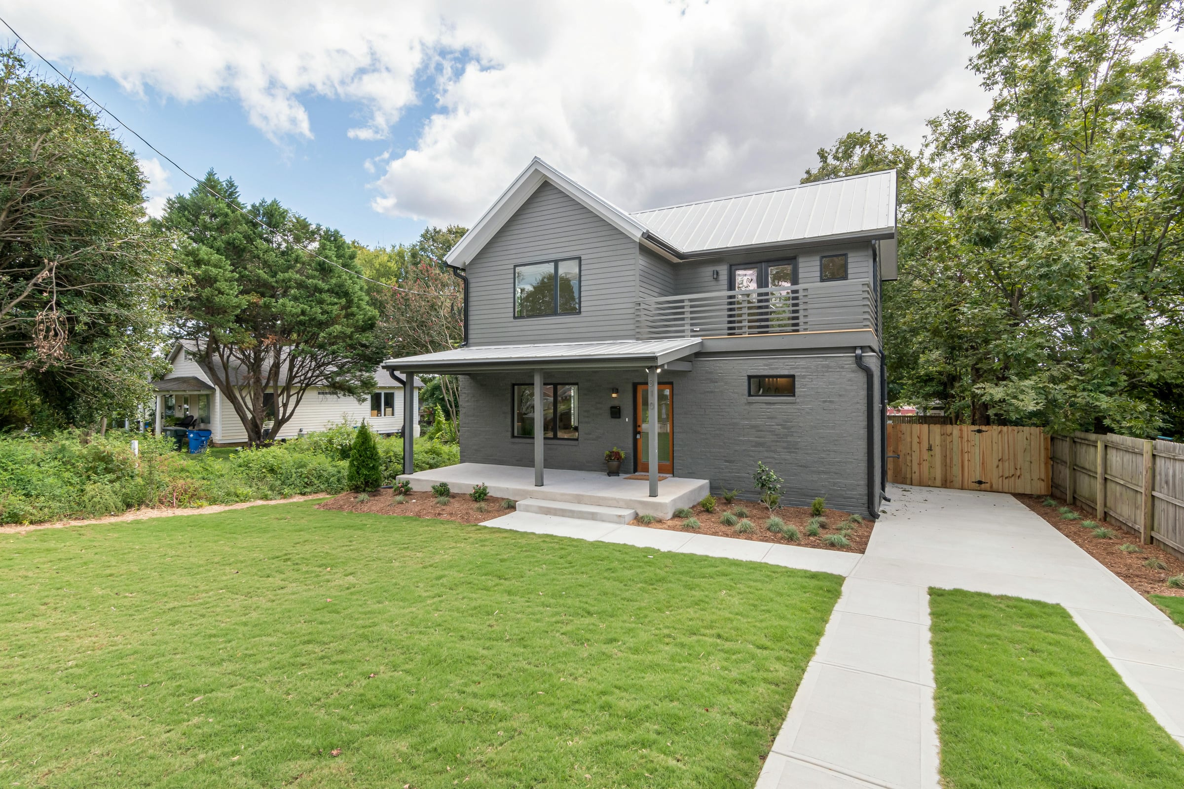 Modern home with a manicured front lawn and landscaped mulch beds